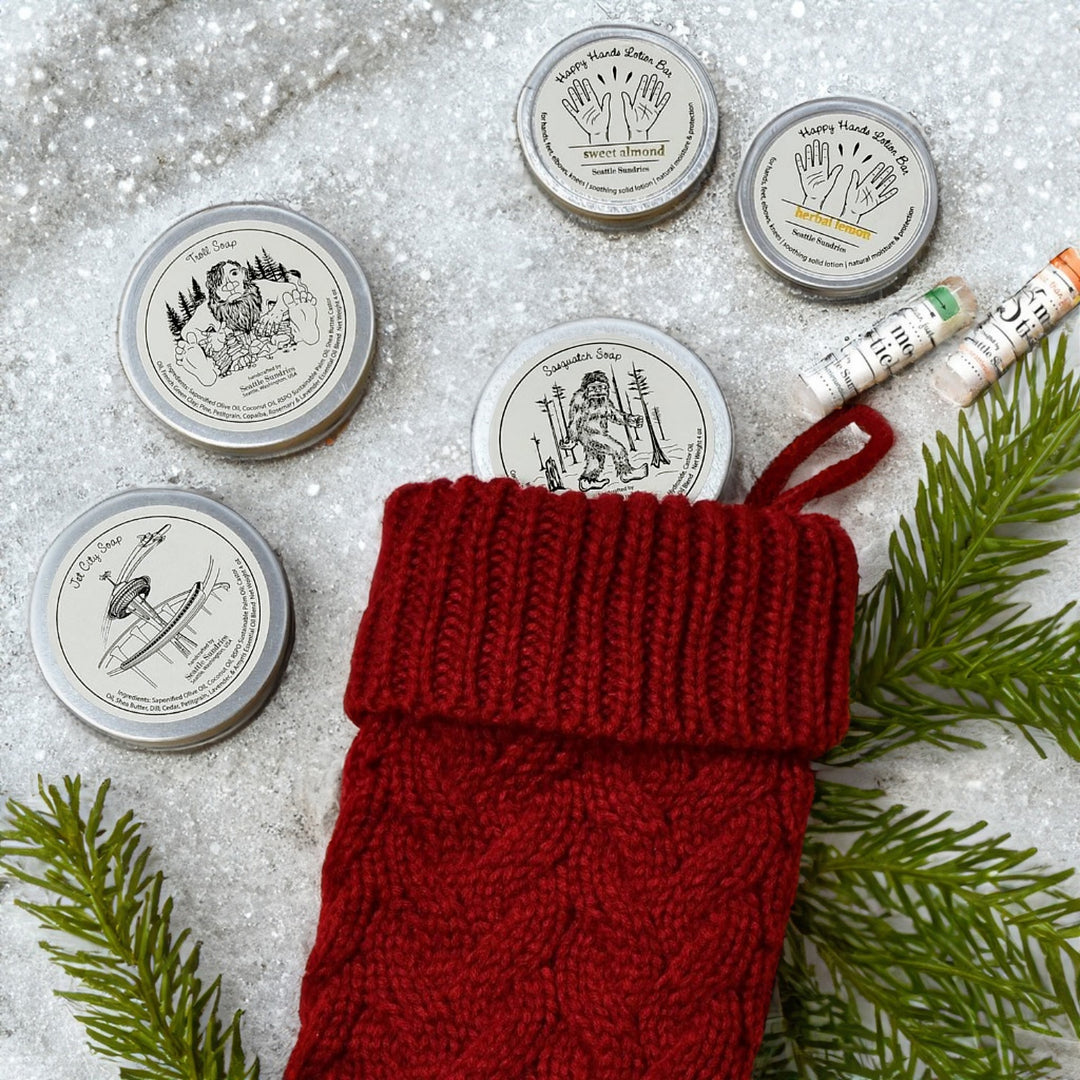 round soap tins with red stocking on snowy background