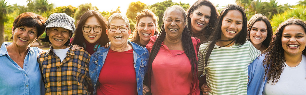 Group of diverse women standing together outdoors, smiling.